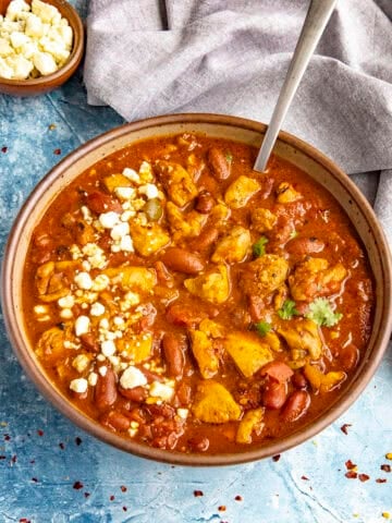 A large bowl of spicy Buffalo Chicken Chili with blue cheese crumbles on top